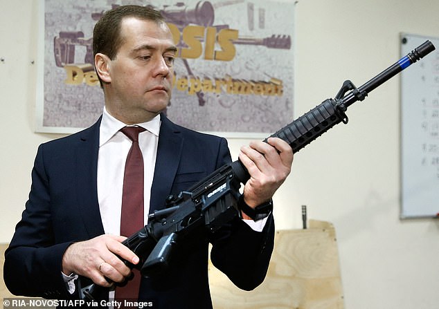 FILE: Russian Prime Minister Dmitry Medvedev holds a Russian-made Orsis weapon during a visit to the Promtechnologiya firearms company in Moscow on November 19, 2013