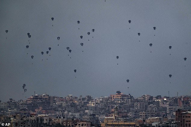 Parachutes drop supplies in the northern Gaza Strip, seen from southern Israel, Friday, March 8, 2024