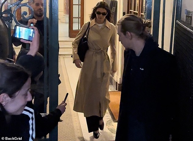 Under the coat, Kendall wore a white T-shirt, wide black pants and black high heels