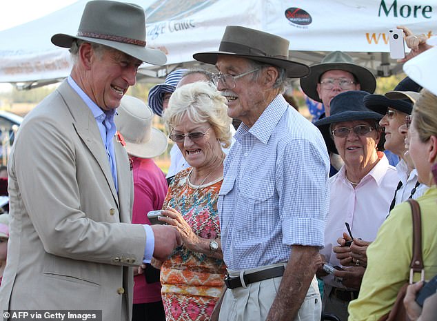 Prince Charles, wearing appropriate headgear, meets locals in the outback of Longreach, Queensland in 2012