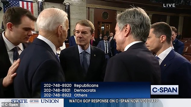 Biden's body man Jacob Spreyer (left) leans in to warn the president about the hot microphone