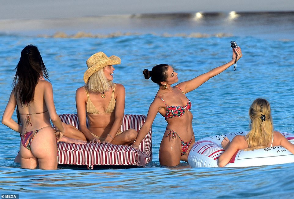 The models were joined by their girlfriends as they lounged on the beach and took selfies together in the water