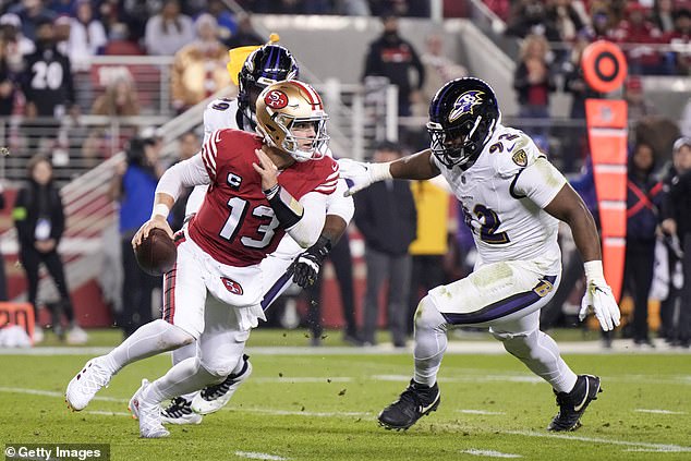 The 49ers' Brock Purdy attempts a pass under pressure from Justin Madubuike in December