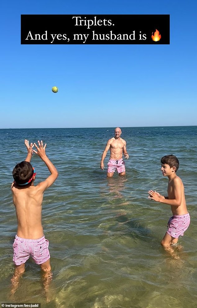 Bec also posted a photo of her husband Chris Judd playing ball in the shallow water with two of their boys