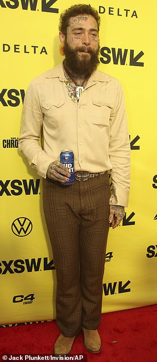 Post Malone nursed a can of Bud Light while wearing a beige button-up shirt and brown patterned pants at the premiere