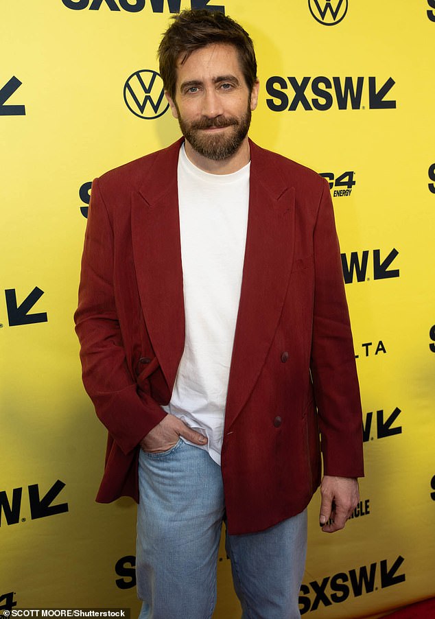 Gyllenhaal wore a dark orange double-breasted jacket on top of a white T-shirt as he posed for a pair of snaps