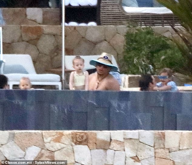 He appeared to see the cameras as he and his daughter Sterling hung out in the water
