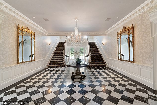 Pictured: The double staircase and checkered floor in the lobby that guests see as they enter the home