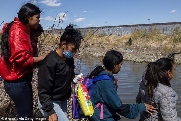 Migrants cross the Rio Grande River to surrender to U.S. authorities in El Paso, Texas