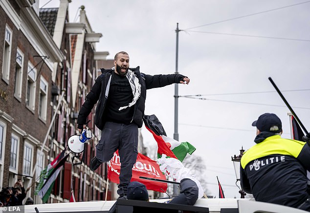 Police officers intervene after a demonstrator climbed onto a mobile unit van during a demonstration