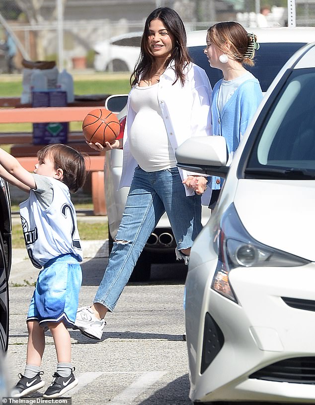 The artist - who recently engaged in some public PDA with her partner - also wore a white button-up shirt and distressed jeans as she stepped out with her family.