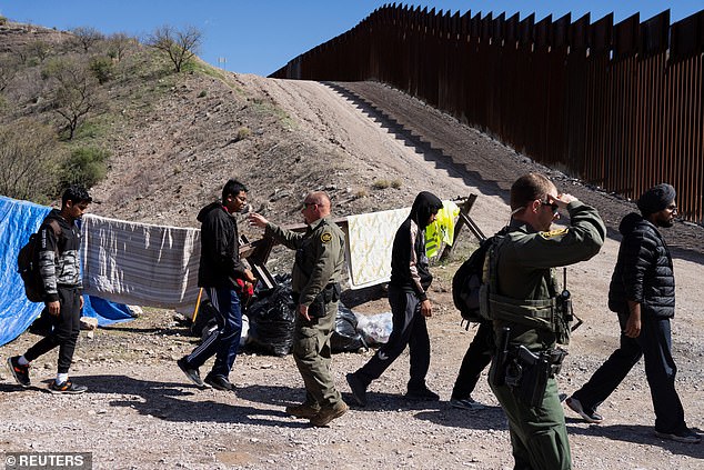 U.S. Border Patrol agents prepare migrants for transport to a processing facility on a remote section of the U.S.-Mexico border near Arizona