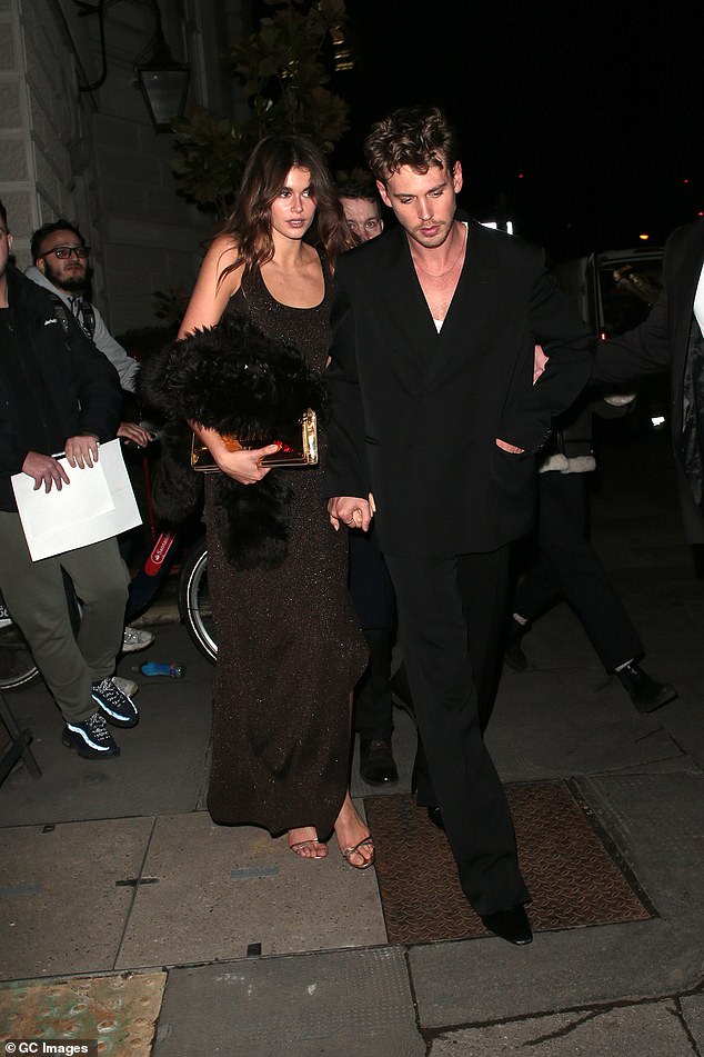 Kaia was seen wearing a sleeveless black maxi dress with a chic coat in hand as she held hands with Austin;  pictured on February 15 in London