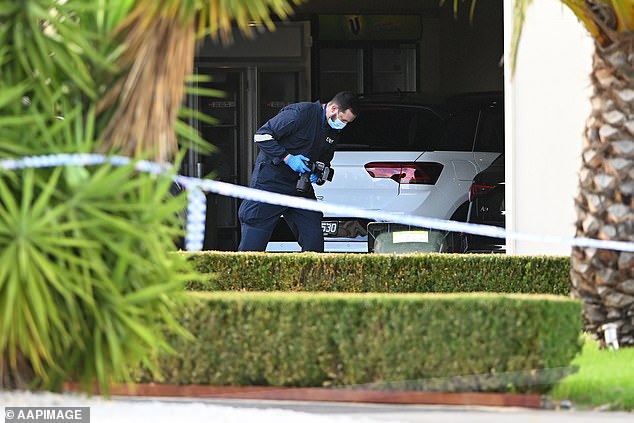 A forensics officer was seen taking photos of the driveway several hours after the alleged shooting