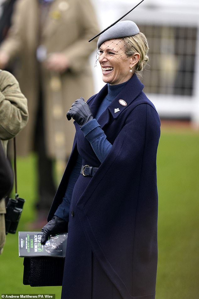 Zara holding her stylish navy blue crocodile leather bag from Fairfax & Favor and program worth £345