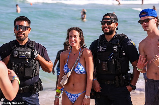 Police officers happily posed with spring breakers on the beach in Fort Lauderdale