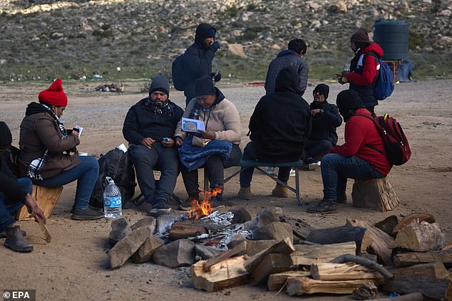 Migrants sit by a campfire in California and wait for U.S. Border Patrol to pick them up