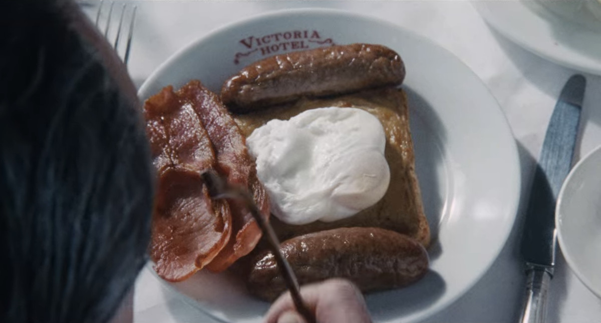 A close-up of a Victoria Hotel plate with bacon, sausage, Welsh rarebit and poached egg