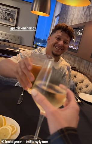 Patrick and Brittany clink their glasses together as they go out to eat