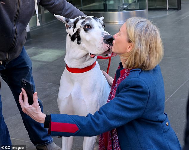 At one point, she knelt on the sidewalk to share a tender moment with her furry companion