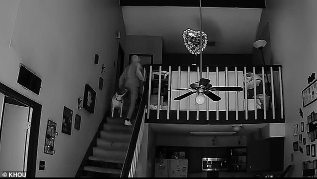 Another camera in Evans' home shows the intruders walking up the stairs and into the bedroom