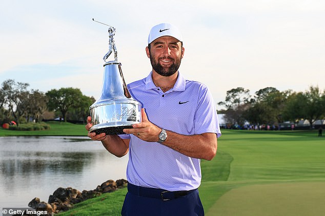 Scottie Scheffler beams as he holds up the Arnold Palmer Invitational trophy on Bay Hill