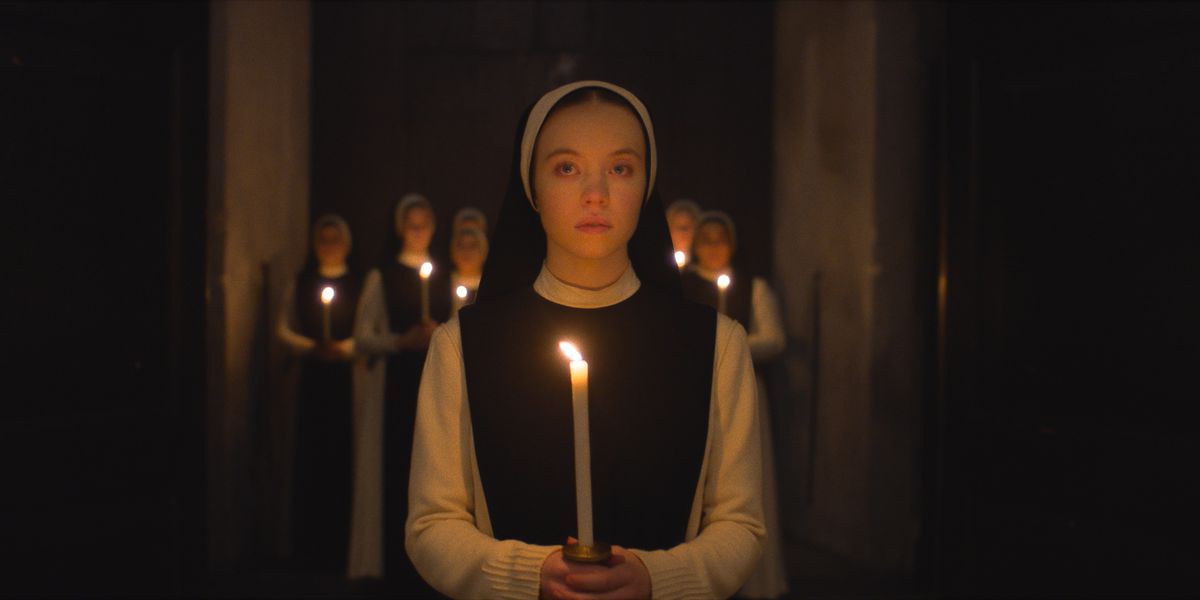 Sydney Sweeney in Immaculate with a candle with nuns behind her 