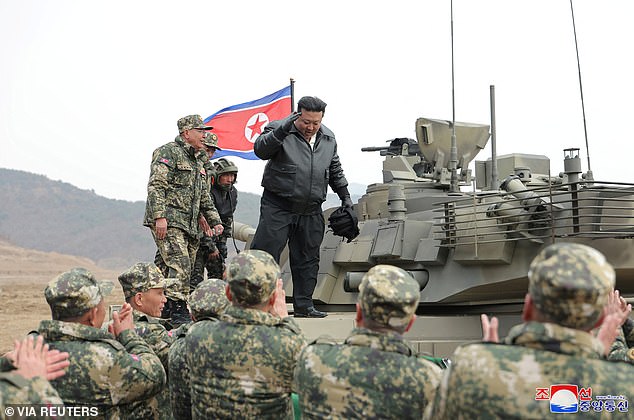 Kim Jong Un (pictured) stood atop a tank as he addressed troops