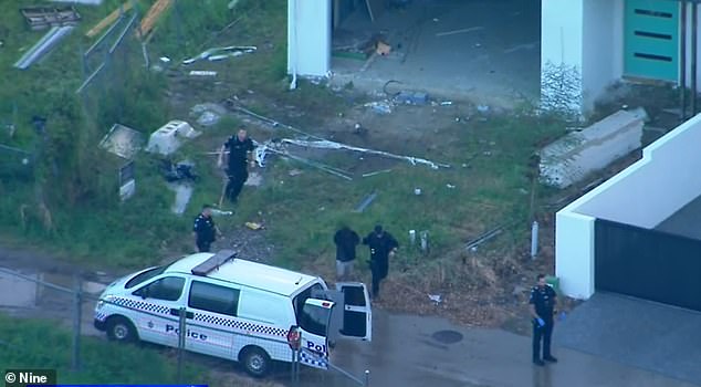 Police take Mr Rawson to a van after handcuffing him following a long manhunt through the gated community and golf course of Sanctuary Cove