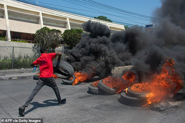 A protester burns tires during a demonstration following the resignation of Prime Minister Ariel Henry, in Port-au-Prince, Haiti, Tuesday