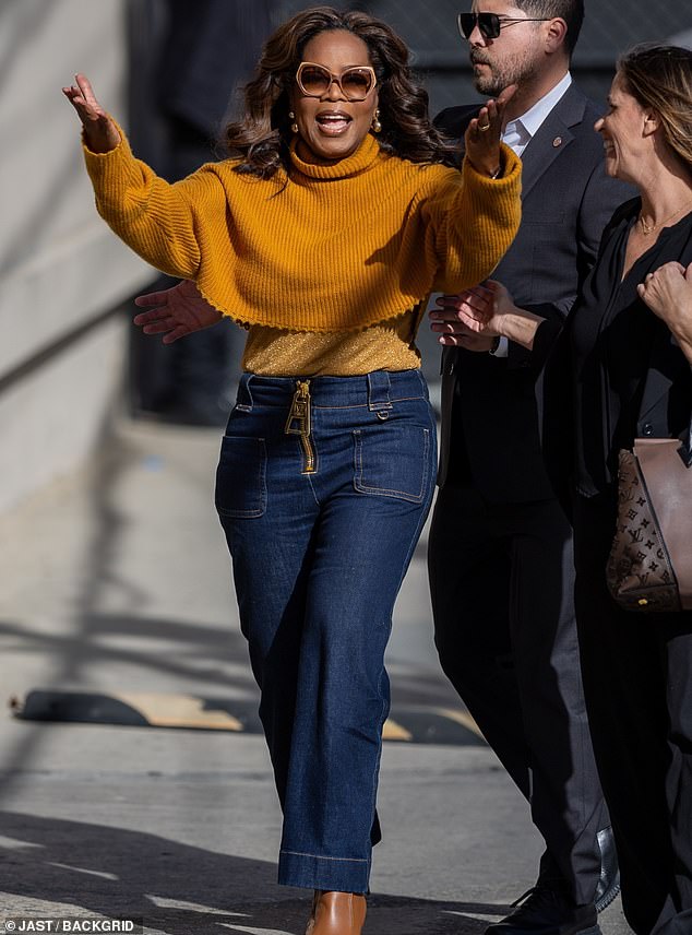 As she entered the studio, Oprah joyfully threw her arms in the air, raising her crop top and highlighting her limited frame.