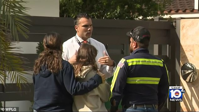 Members of the Miami-Dade Police Department were seen outside the investigation site, although the names of those involved have yet to be released.  Pictured: Detectives comforting at least one of the woman's children