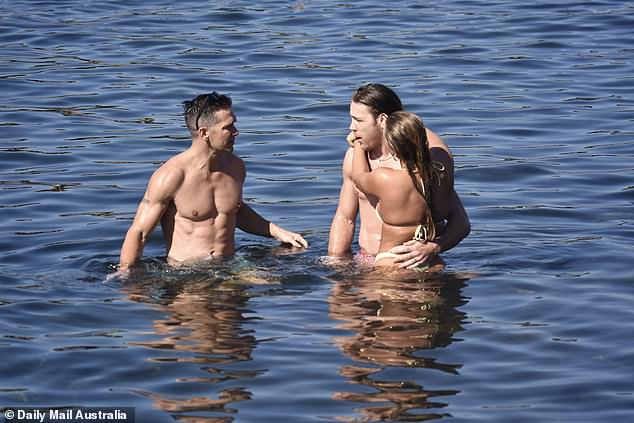 Jono showed off his muscular body as he went shirtless into the sea, while Eden stood with her arms around Jayden.