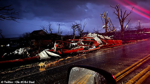 What's left of campers lie twisted and broken along the side of the road, next to fallen trees