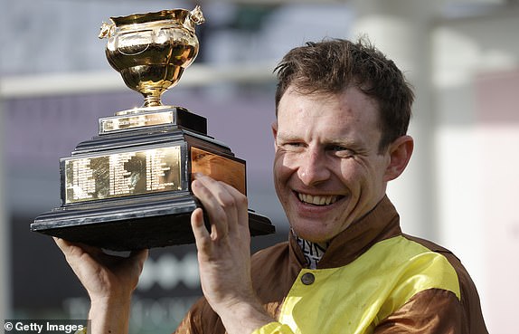 Jockey Paul Townend holds the trophy after winning Galopin Des Champs in the Gold Cup while racing on day four of the Cheltenham National Hunt jump racing festival at Cheltenham Racecourse on March 17, 2023 in Gloucestershire, England (Photo by Tom Jenkins/Getty Images)