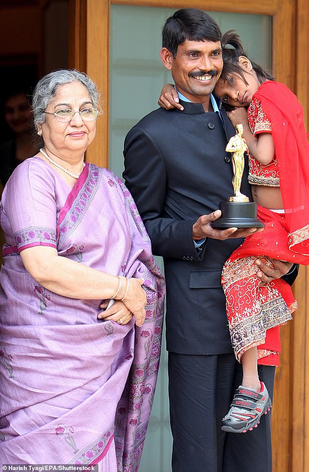 Pinki Sonkar is carried by her father during a photo with the wife of then Indian Prime Minister Gurcharan Singh Kaur