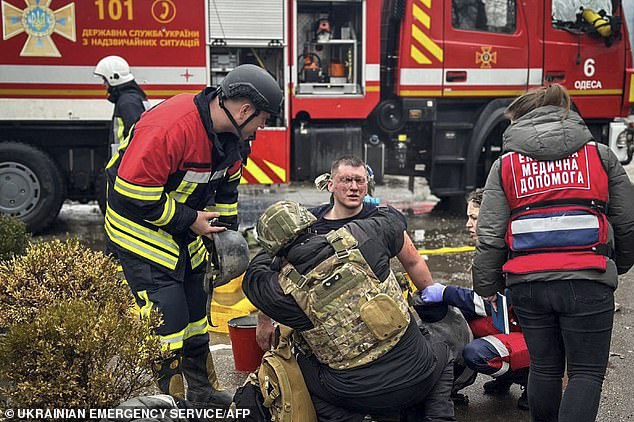 Medical personnel assisting an injured rescuer after a rocket attack in Odessa