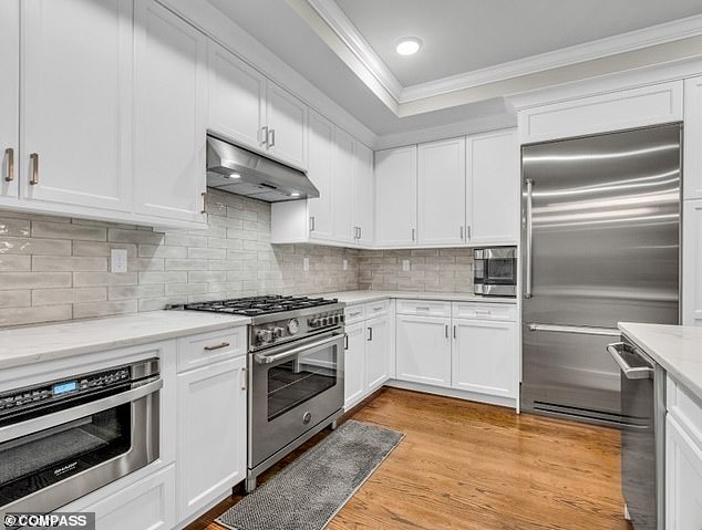 The kitchen features stainless steel appliances, including a washer and dryer