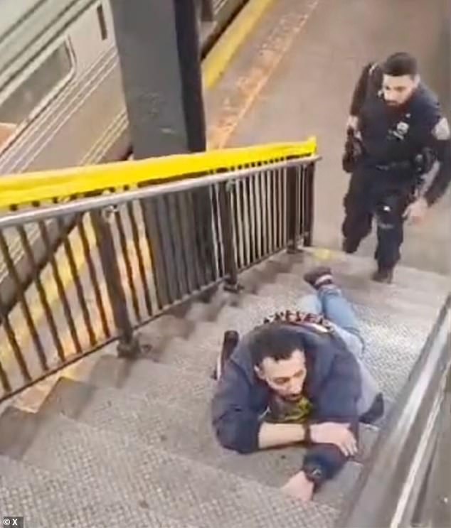 The 32-year-old gunman was arrested before entering the platform and remained in custody.  He is seen lying on the stairs outside the subway