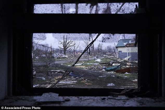 Debris is visible through the window of a damaged home after heavy storms in Lakeview, Ohio