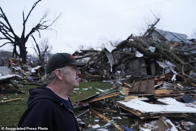 Greg McDougle walks near debris on Friday, March 15, 2024, after the suspected tornado in Lakeview