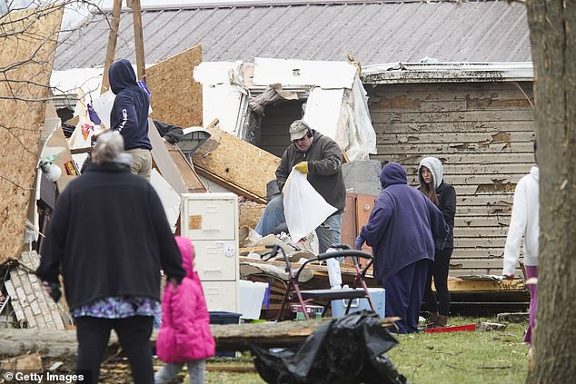 Families and neighbors help each other clean up after a tornado hit the area in Indian Lake, Ohio