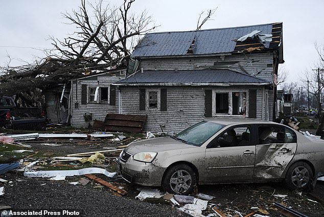 Debris is visible near a damaged home as a result of the extreme weather conditions that tore through the Midwest Thursday night and Friday morning