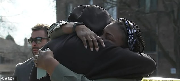 Pictured: Neighbors embracing as they mourn the death of Jayden Perkins