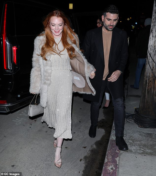 Her husband sweetly escorted her to the sidewalk as they got out of a car, and held her hands as they strolled to the Italian restaurant.