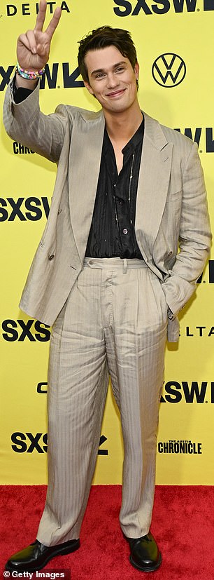 The 29-year-old English actor treated photographers to his winning smile and raised one arm to show a friendly peace sign