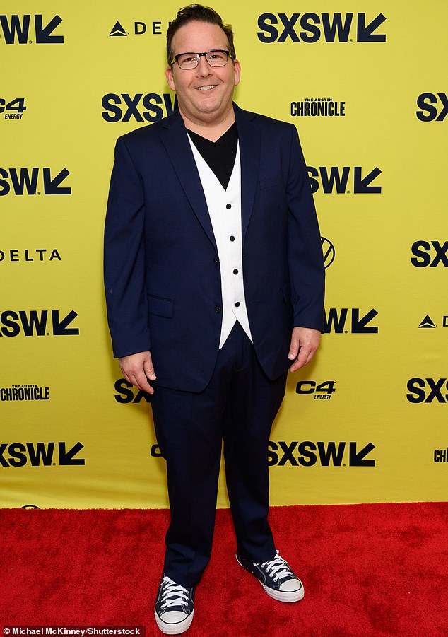 Jon Levine wore a navy blue suit over a white vest that elegantly contrasted with the black v-neck he opted for in place of a shirt