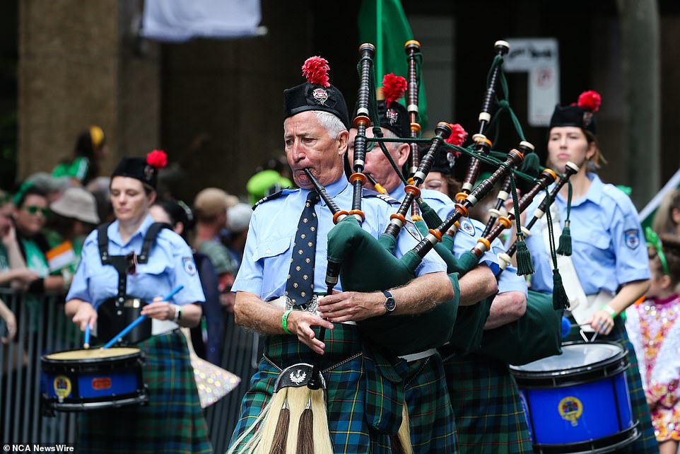 A man is seen playing the bagpipes as he takes part in the St. Patrick's Day parade in Sydney's CBD