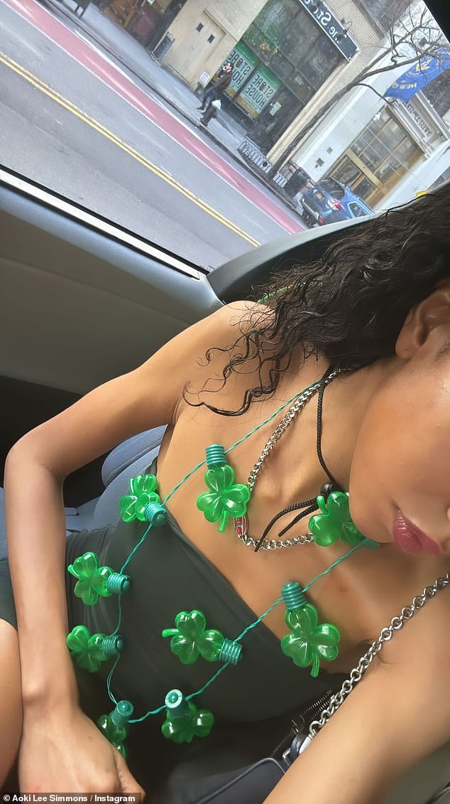 Aoki Lee Simmons, 21, shared a photo of herself wearing a string of green shamrock lights as a necklace over a black mini dress to her Instagram Stories