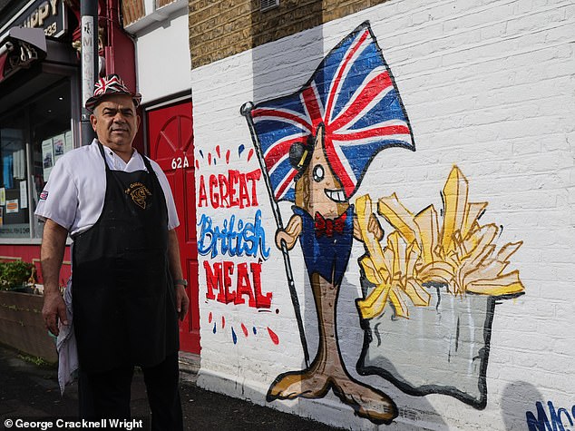 Pictured: Chris Kanizi, owner of Golden Chippy, standing next to the Union Flag mural on the side of his restaurant